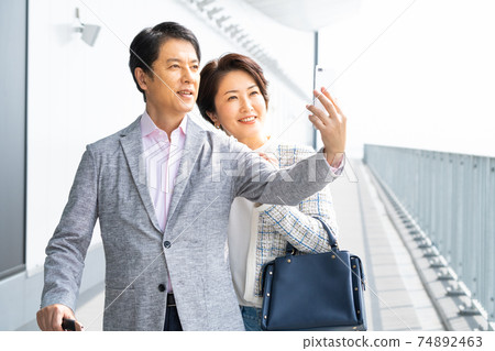 中間夫婦採取與智能手機自拍照 中間夫婦採取與智能手機自拍照 74892463