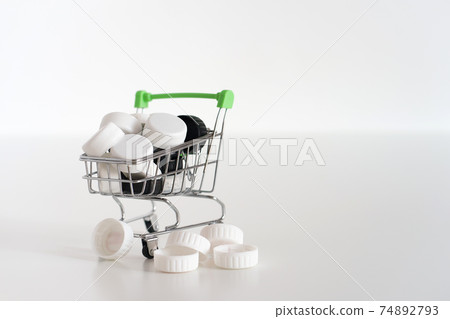 Black and white lids in a small shopping cart Black and white lids in a small shopping cart 74892793