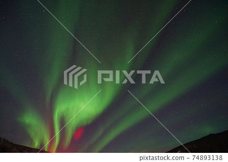 Aurora borealis in the night sky. The light colors are green, yellow, and red. Photographed in Alaska, the USA on March 17, 2016 Aurora borealis in the night sky. The light colors are green, yellow, and red. Photographed in Alaska, the USA on March 17, 2016 74893138