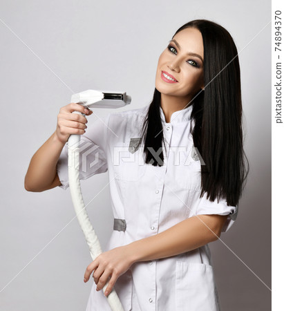 Smiling young brunette woman doctor cosmetologist Smiling young brunette woman doctor cosmetologist 74894370