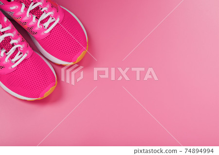 Sports pink sneakers on a pink background with free space. Sports pink sneakers on a pink background with free space. 74894994