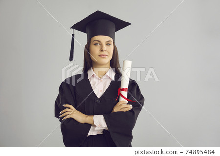 Woman university graduate in traditional bonet and mantle standing with diploma in hand Woman university graduate in traditional bonet and mantle standing with diploma in hand 74895484