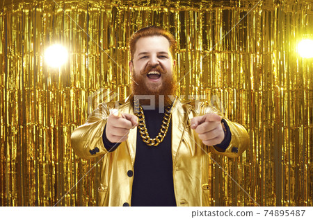 Funny fat man in golden costume pointing at camera and feeling cheerful Funny fat man in golden costume pointing at camera and feeling cheerful 74895487