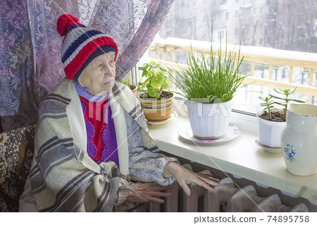 Woman holding cash in front of heating radiator. Payment for heating in winter. Selective focus. 74895758