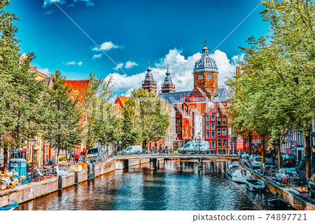 AMSTERDAM, NETHERLANDS- SEPTEMBER 15, 2015: Westerkerk (Western Church), with water canal view in Amsterdam. Netherlands. AMSTERDAM, NETHERLANDS- SEPTEMBER 15, 2015: Westerkerk (Western Church), with water canal view in Amsterdam. Netherlands. 74897721