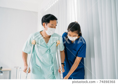 Young nurse helping patient walk 74898368