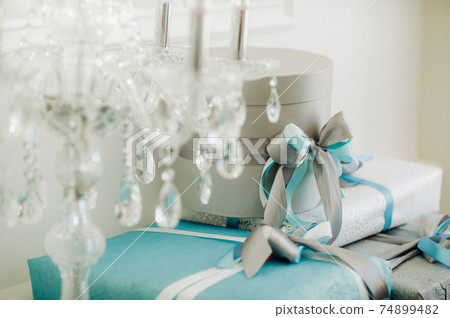 Boxes with gifts Packed in blue and silver paper are on the shelf Boxes with gifts Packed in blue and silver paper are on the shelf 74899482