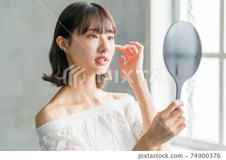十幾歲的女孩看著手鏡 十幾歲的女孩看著手鏡 74900376