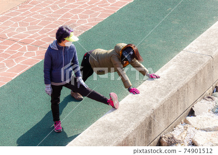 Women stretching before exercise Women stretching before exercise 74901512