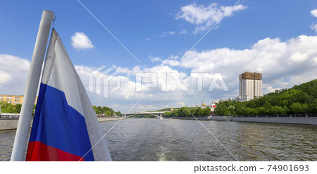Russia flag and  building of the Presidium of Russian Academy of Sciences and Moskva River, Moscow, Russia.  Shooting from a tourist pleasure boat 74901693