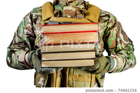 Isolated photo of a soldier in uniform holding stack of books on white background, front view. Isolated photo of a soldier in uniform holding stack of books on white background, front view. 74902158