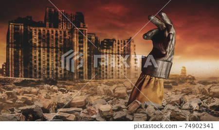 Photo of a stalker hand in rubber glove buried under bricks on desolate destructed  apocalyptic city. 74902341