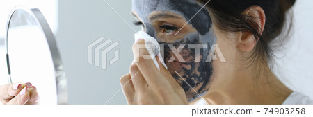 Woman takes off her anti-aging face mask 74903258