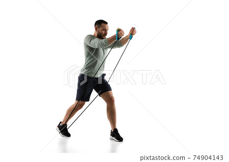 Young caucasian male model in action, motion isolated on white background. Concept of sport, movement, energy and dynamic, healthy lifestyle. Training, practicing. 74904143
