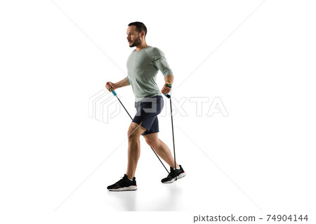 Young caucasian male model in action, motion isolated on white background. Concept of sport, movement, energy and dynamic, healthy lifestyle. Training, practicing. 74904144