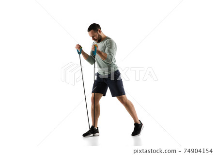 Young caucasian male model in action, motion isolated on white background. Concept of sport, movement, energy and dynamic, healthy lifestyle. Training, practicing. 74904154