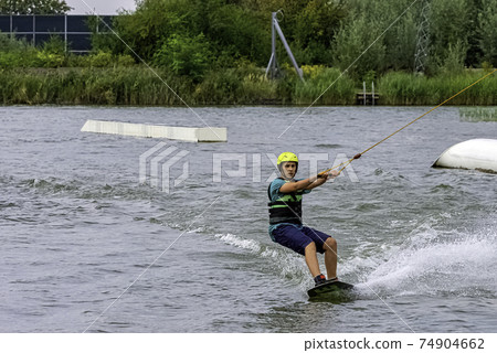 Teenager wakeboarding on a lake - Brwinow, Masovia, Poland Teenager wakeboarding on a lake - Brwinow, Masovia, Poland 74904662