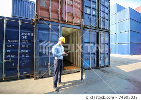 Engineer or supervisor checking and control loading Containers box from Cargo at harbor.Foreman control Industrial Container Cargo freight ship at industry.Transportation and logistic concept. 74905032