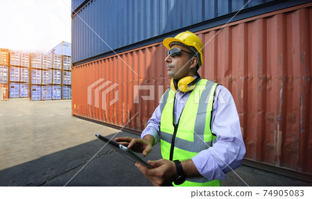 Foreman control loading Containers box from Cargo freight ship for import export. Foreman control loading Containers box from Cargo freight ship for import export. 74905083