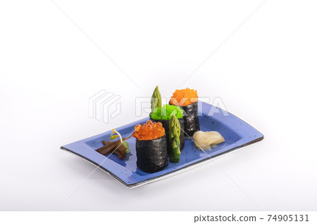 Close up of beautiful maki pieces with pickled ginger and asparagus on a small tray on a light background. Sushi and healthy food concept. Close up of beautiful maki pieces with pickled ginger and asparagus on a small tray on a light background. Sushi and healthy food concept. 74905131