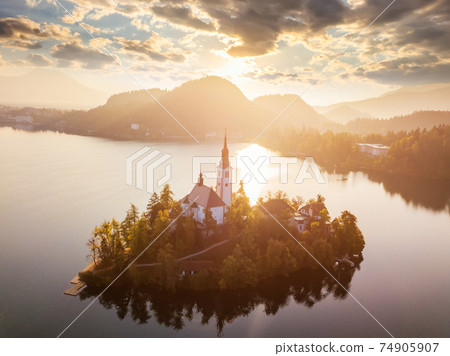 Bled Lake with Pilgrimage Church of the Assumption of Maria at sunrise. Aerial view Bled Lake with Pilgrimage Church of the Assumption of Maria at sunrise. Aerial view 74905907