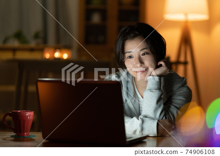 看一台計算機的少婦在客廳在晚上 74906108