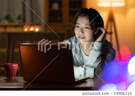 看一台計算機的少婦在客廳在晚上 74906110