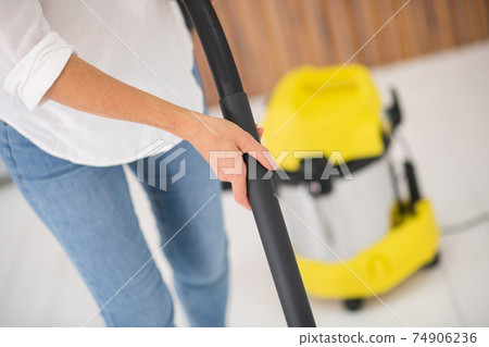 Female hands holding tube of vacuum cleaner Female hands holding tube of vacuum cleaner 74906236