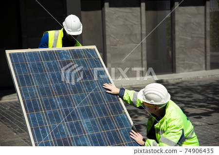 technicians install panels Solar cells to produce and distribute electricity. Energy technology concept technicians install panels Solar cells to produce and distribute electricity. Energy technology concept 74906435