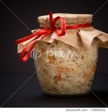 Fermented cabbage with herbs and spices in glass jar on the black background 74906592