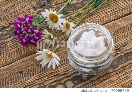 Cosmetic cream, fresh chamomile and verbena flowers on wooden background. Cosmetic cream, fresh chamomile and verbena flowers on wooden background. 74906799