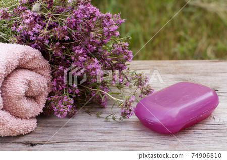 Towel with thyme flowers and soap on wooden background. 74906810