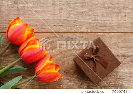 Gift box with ribbons on wooden boards. Gift box with ribbons on wooden boards. 74907484