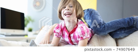 Girl and boy play around on couch at home and laugh. Girl and boy play around on couch at home and laugh. 74907649