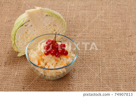 Fermented cabbage with herbs and spices in glass bowl on sackcloth. 74907813
