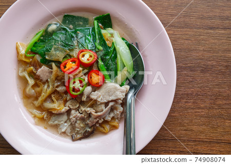Fried Wide Rice Noodles with Pig in Gravy Sauce on the Wood Table 74908074
