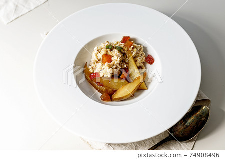 Oatmeal with fruits on a white plate. Sweet pear and candied fruits. Delicious and healthy breakfast. Ideas and recipes for home meals. Oatmeal with fruits on a white plate. Sweet pear and candied fruits. Delicious and healthy breakfast. Ideas and recipes for home meals. 74908496
