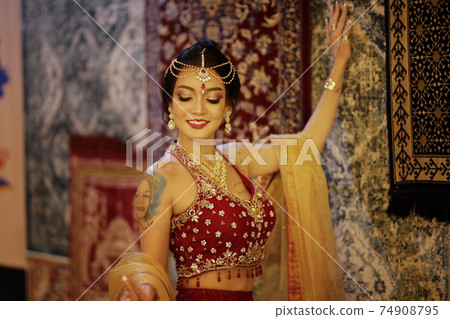 Portrait of beautiful indian girl . Young hindu woman model in sari and kundan jewelry . Traditional India costume lehenga choli . Eastern or Arabic culture. 74908795