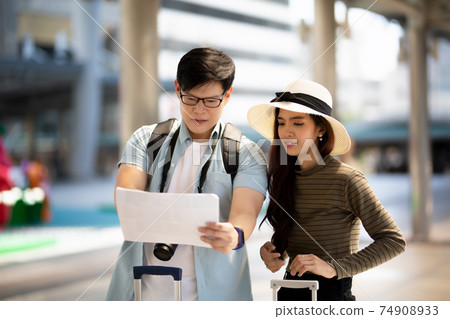 Asian couple enjoy travelling and walking on the street in city. 74908933