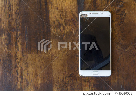 Modern mobile phone with a broken screen 74909005