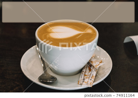 Mug of coffee is on the table latte art in the shape of a heart Mug of coffee is on the table latte art in the shape of a heart 74911164