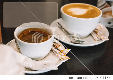 Two cups of different coffee on rustic wooden table. Symbolic image. Copy space Two cups of different coffee on rustic wooden table. Symbolic image. Copy space 74911168
