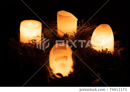 Burning candles on an advent wreast in the dark 74911171