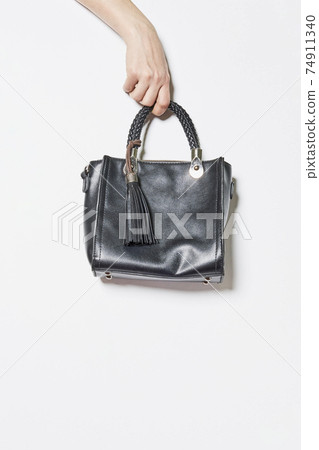 Hand holds handbag 74911340