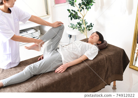 A woman receiving a massage during chiropractic pelvic correction A woman receiving a massage during chiropractic pelvic correction 74912022
