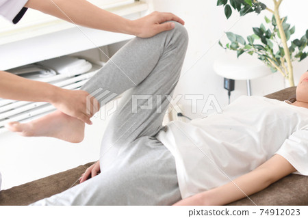A woman receiving a massage during chiropractic pelvic correction A woman receiving a massage during chiropractic pelvic correction 74912023