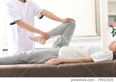 A woman receiving a massage during chiropractic pelvic correction A woman receiving a massage during chiropractic pelvic correction 74912026