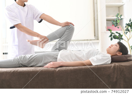 A woman receiving a massage during chiropractic pelvic correction 74912027