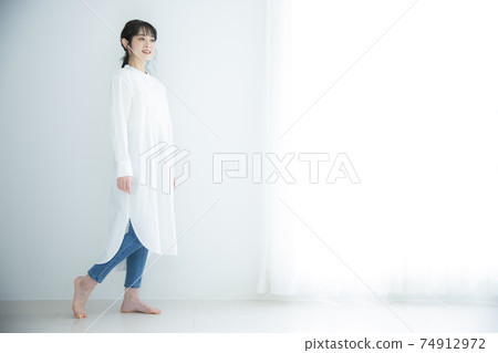 A woman in a white shirt dress 74912972