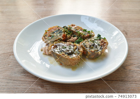 slice boiled black preserved egg dressing spicy fried chop pork and basil leaf on plate slice boiled black preserved egg dressing spicy fried chop pork and basil leaf on plate 74913073